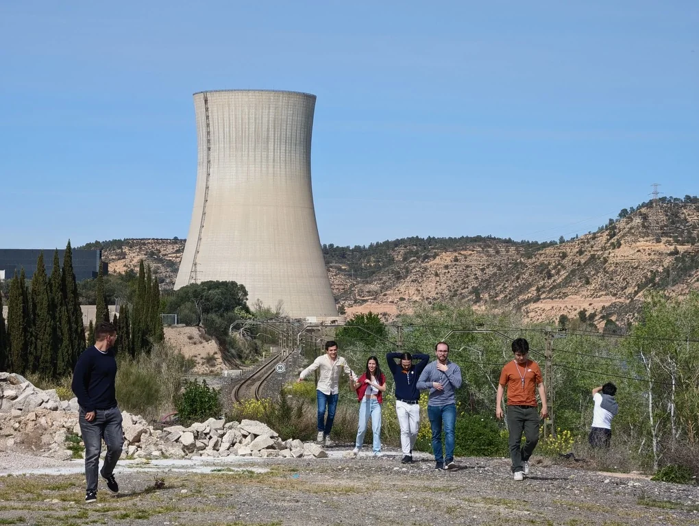Nuclear Vision Portugal members walking beside a cooling tower during a reactor site visit